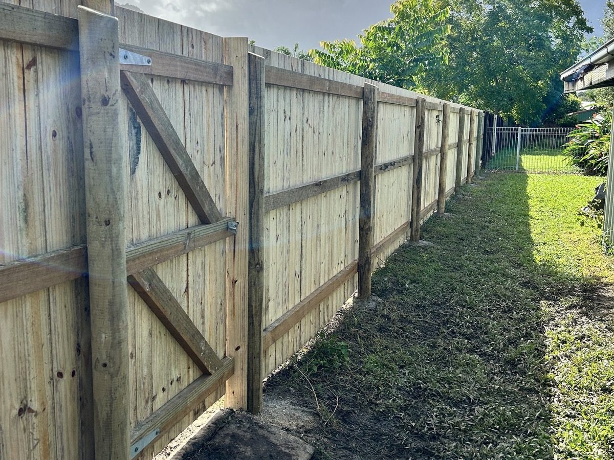 A capped timber paling fence running the length of a back lawn
