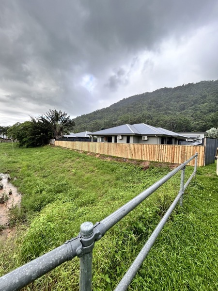 A new timber paling fence running along a green hillside