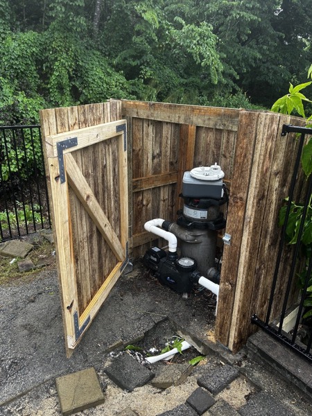 A rustic timber gate standing open beside a garden path