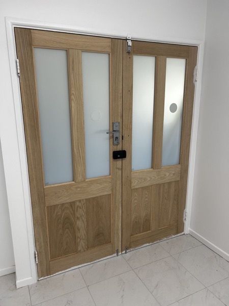 A pair of timber-framed internal doors with frosted glass panels
