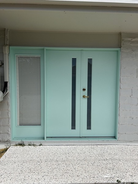 Painted double entry doors with long vertical pull handles