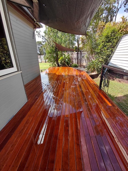 Close-up of freshly oiled hardwood decking boards catching the light